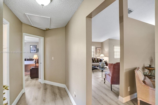 1930 W Oak Knoll Cir, Davie, FL 33324 - hall with light wood-style flooring, a textured ceiling, baseboards, and attic access