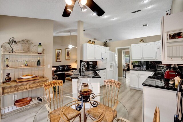1930 W Oak Knoll Cir, Davie, FL 33324 - kitchen featuring a ceiling fan, vaulted ceiling, dark countertops, backsplash, and white cabinets