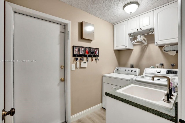 1930 W Oak Knoll Cir, Davie, FL 33324 - laundry area with washer and clothes dryer, cabinet space, light wood finished floors, baseboards, and a textured ceiling