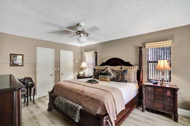 1930 W Oak Knoll Cir, Davie, FL 33324 - bedroom with light wood-style floors, ceiling fan, a textured ceiling, and baseboards