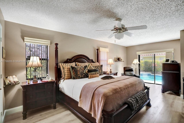 1930 W Oak Knoll Cir, Davie, FL 33324 - bedroom with access to exterior, light wood-style floors, a textured ceiling, baseboards, and a ceiling fan