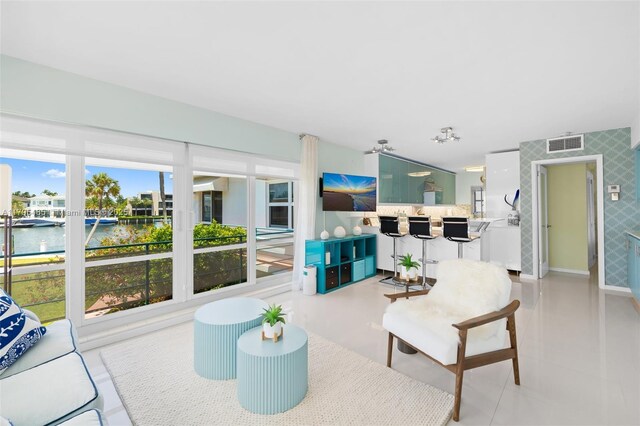 living area with wallpapered walls, a water view, and baseboards