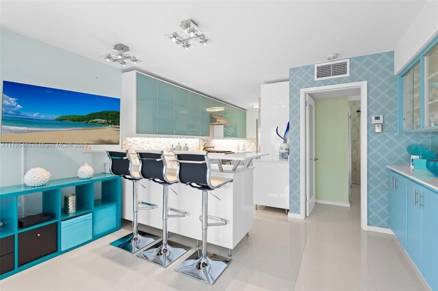 kitchen featuring backsplash, a kitchen breakfast bar, and baseboards