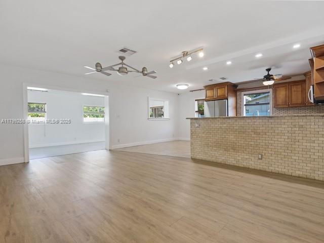 2650 NW 67th Ter, Margate, FL 33063 - unfurnished living room with ceiling fan, light wood-type flooring, brick wall, and recessed lighting