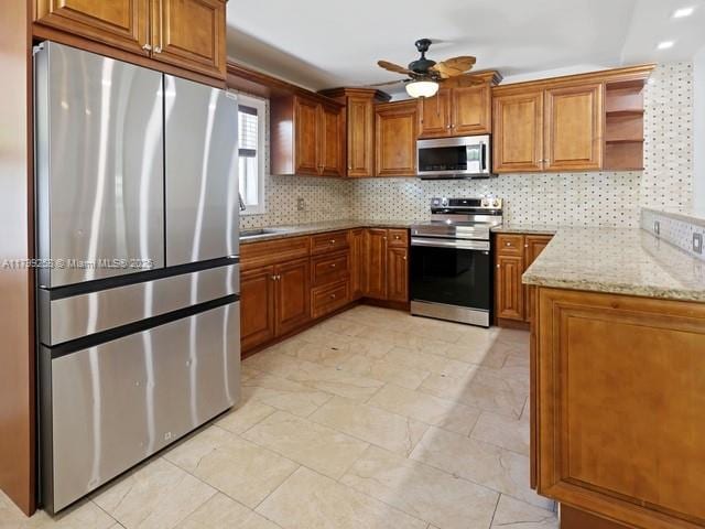 2650 NW 67th Ter, Margate, FL 33063 - kitchen with stainless steel appliances, brown cabinets, ceiling fan, and tasteful backsplash