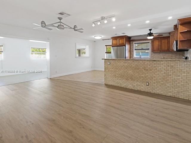 2650 NW 67th Ter, Margate, FL 33063 - kitchen featuring freestanding refrigerator, ceiling fan, open shelves, a peninsula, and healthy amount of natural light