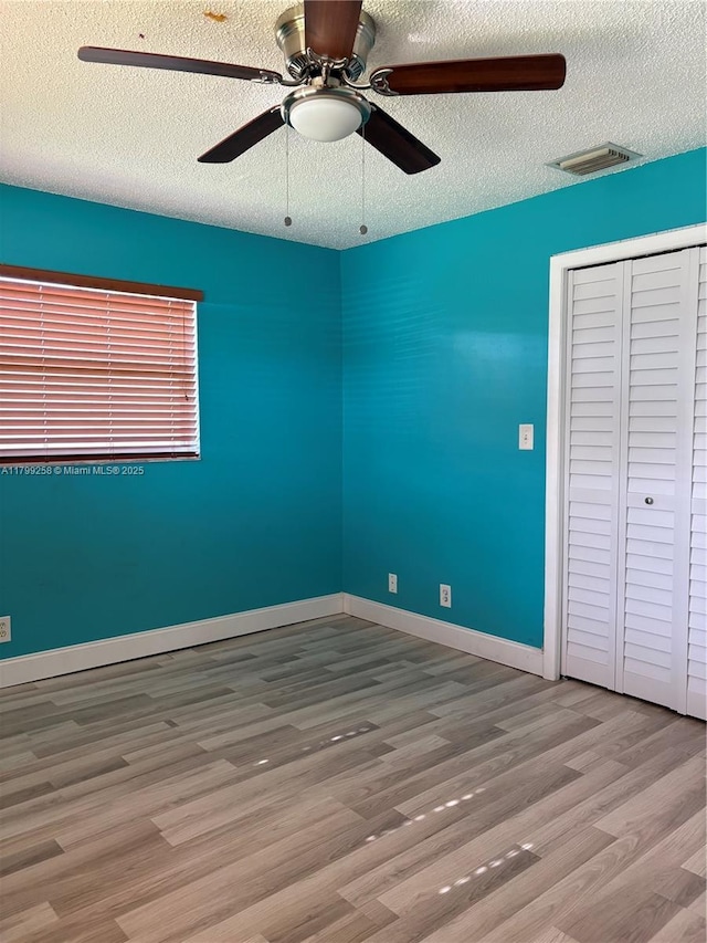 2650 NW 67th Ter, Margate, FL 33063 - unfurnished bedroom featuring a textured ceiling, wood finished floors, a ceiling fan, and a closet