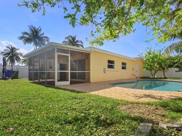2650 NW 67th Ter, Margate, FL 33063 - back of property featuring a sunroom, an outdoor pool, stucco siding, and a patio