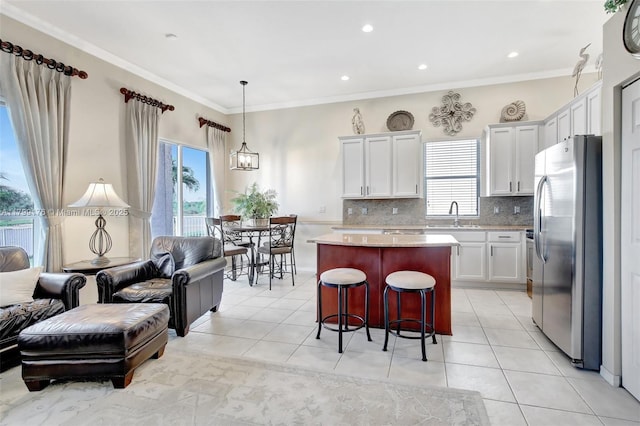 14284 NW 18th Mnr, Pembroke Pines, FL 33028 - kitchen with freestanding refrigerator, a kitchen island, healthy amount of natural light, tasteful backsplash, and ornamental molding