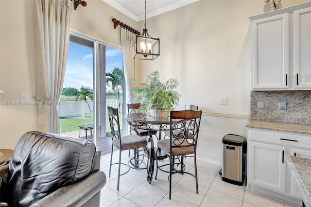 14284 NW 18th Mnr, Pembroke Pines, FL 33028 - dining space with ornamental molding, a chandelier, light tile patterned flooring, and baseboards