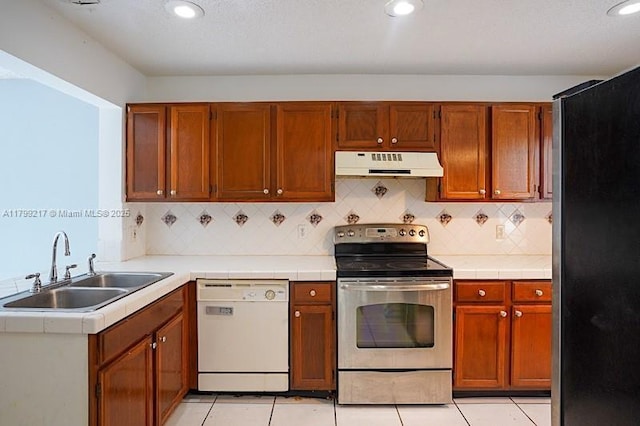5154 Breckenridge Pl Unit 47, West Palm Beach, FL 33417 - kitchen featuring appliances with stainless steel finishes, under cabinet range hood, a sink, light tile patterned flooring, and tasteful backsplash