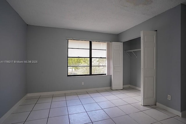 5154 Breckenridge Pl Unit 47, West Palm Beach, FL 33417 - unfurnished bedroom with a textured ceiling, baseboards, light tile patterned floors, and a closet