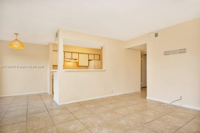 unfurnished room with light tile patterned flooring and baseboards