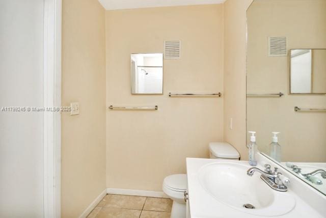 bathroom featuring a sink, toilet, baseboards, and tile patterned floors