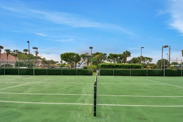 view of tennis court featuring fence