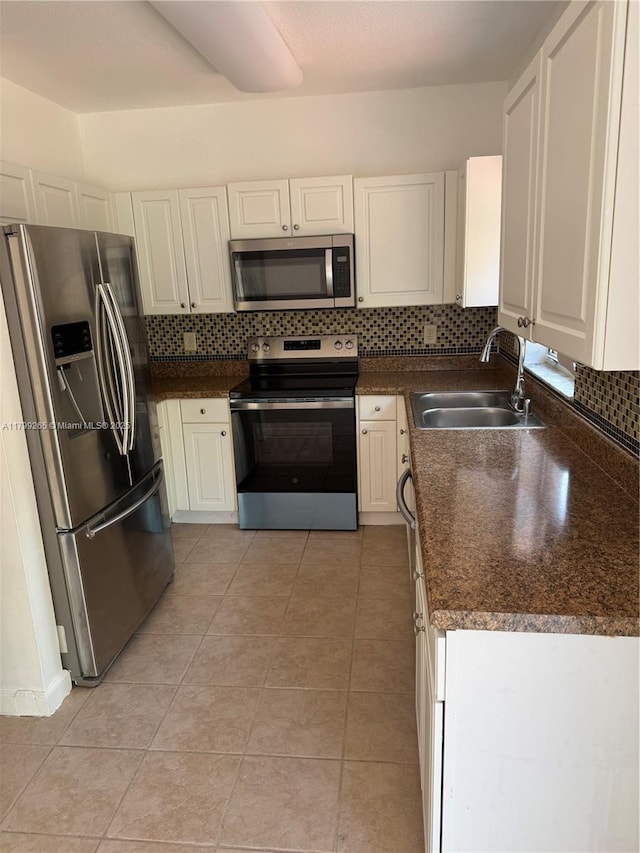 4139 NE 26th St, Homestead, FL 33033 - kitchen with appliances with stainless steel finishes, dark countertops, backsplash, and white cabinets