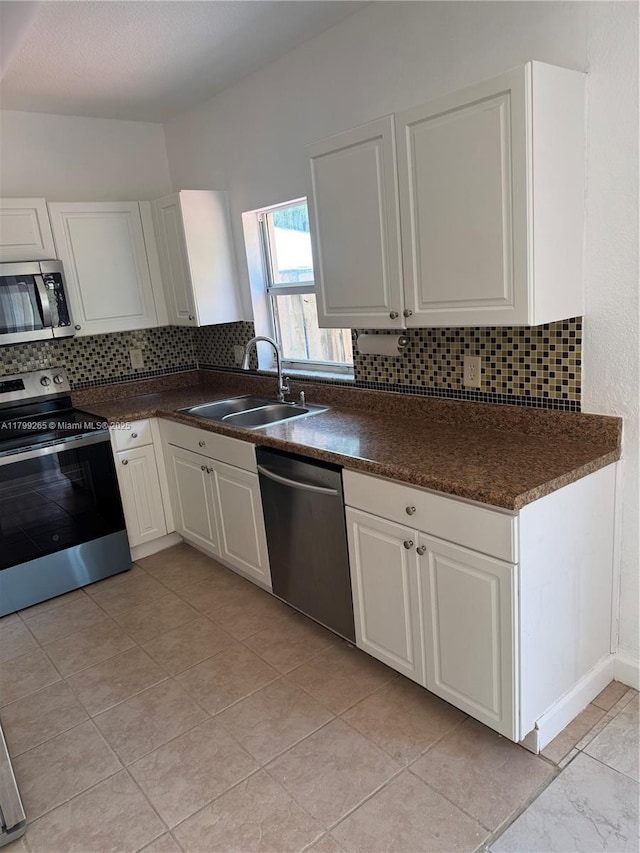 4139 NE 26th St, Homestead, FL 33033 - kitchen with stainless steel appliances, backsplash, dark countertops, and white cabinets