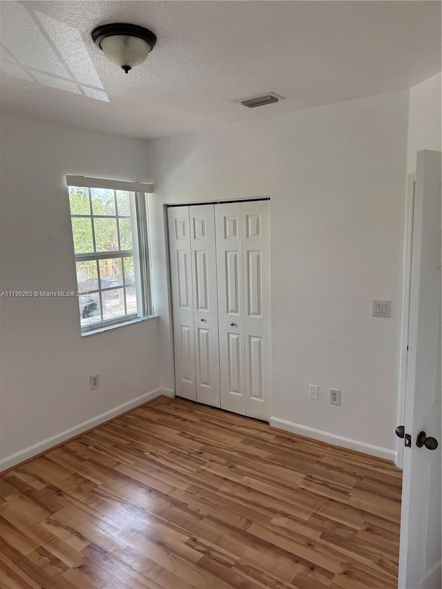 4139 NE 26th St, Homestead, FL 33033 - unfurnished bedroom featuring wood finished floors, a closet, and a textured ceiling