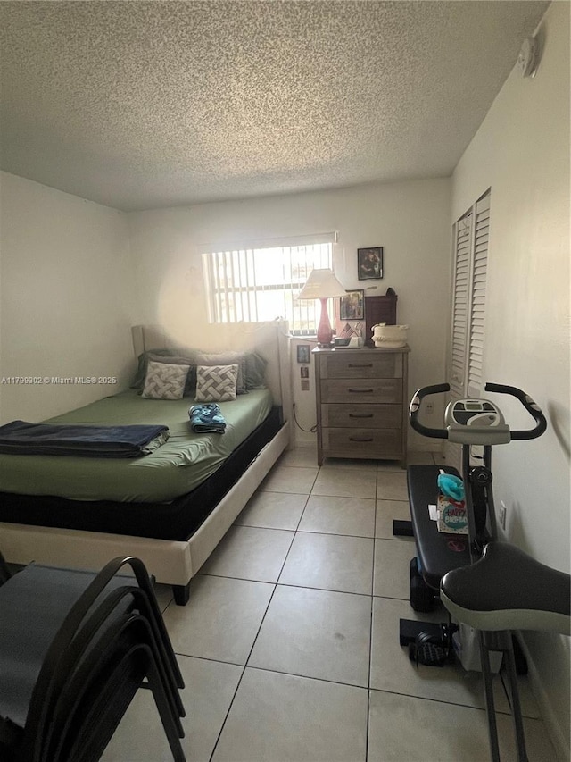 8145 NW 7th St Unit 211, Miami, FL 33126 - bedroom featuring a textured ceiling, light tile patterned floors, and a closet