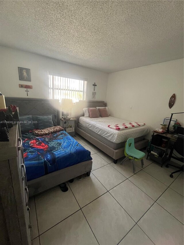 8145 NW 7th St Unit 211, Miami, FL 33126 - bedroom featuring a textured ceiling and light tile patterned flooring