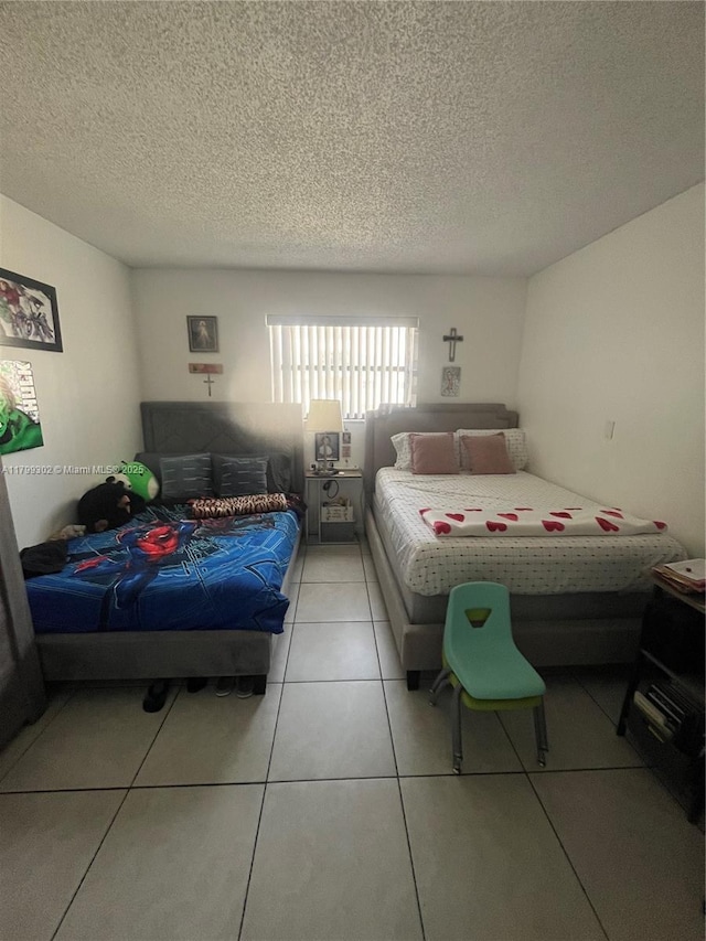 8145 NW 7th St Unit 211, Miami, FL 33126 - bedroom featuring a textured ceiling and tile patterned flooring