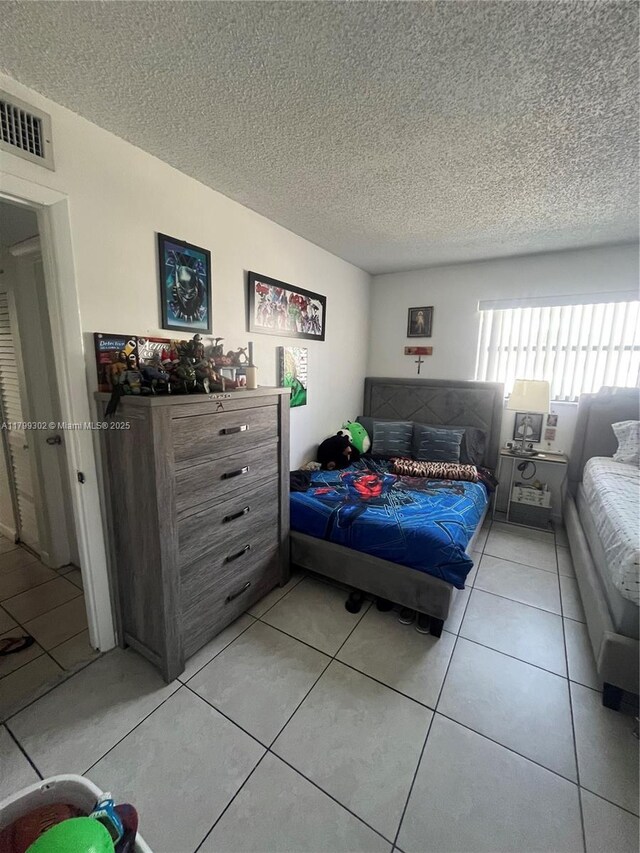 8145 NW 7th St Unit 211, Miami, FL 33126 - bedroom with a textured ceiling and light tile patterned flooring