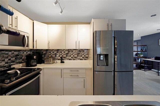 9054 NW 193rd Ter, Hialeah, FL 33018 - kitchen with appliances with stainless steel finishes, light countertops, decorative backsplash, white cabinets, and recessed lighting