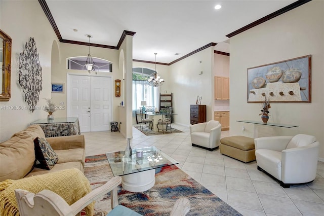 living room featuring a chandelier, ornamental molding, light tile patterned floors, arched walkways, and baseboards