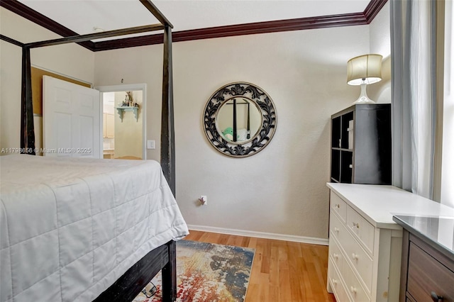 bedroom featuring crown molding, light wood finished floors, and baseboards