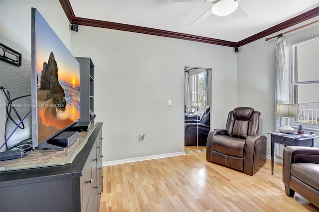 sitting room featuring crown molding, light wood-style floors, ceiling fan, and baseboards