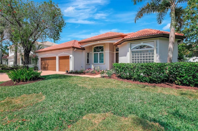 mediterranean / spanish-style house with an attached garage, a tiled roof, a front lawn, and stucco siding