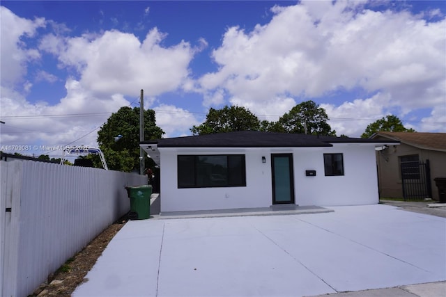 view of front of property with fence and stucco siding