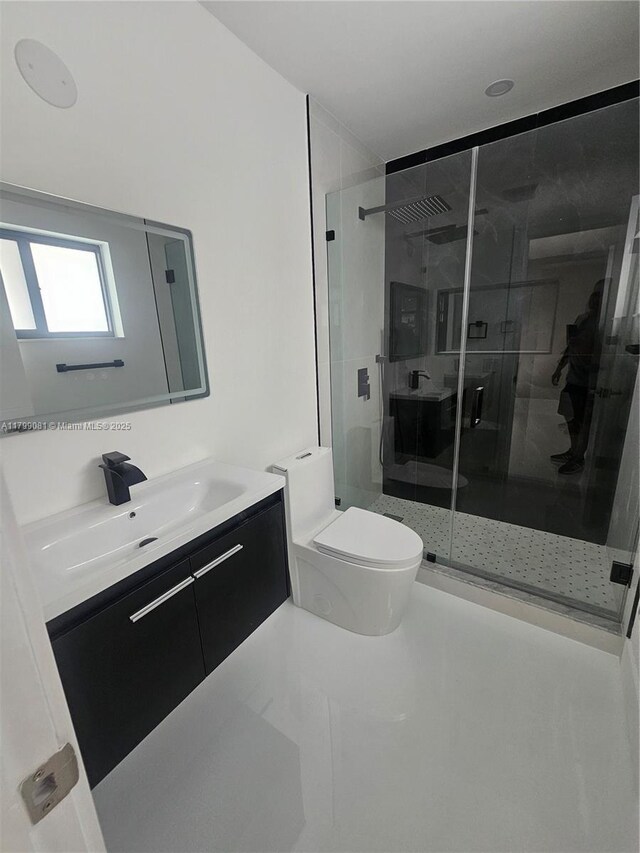 bathroom with toilet, a shower stall, and vanity