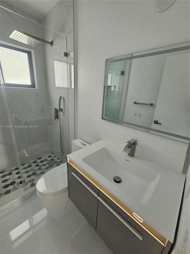 full bathroom with toilet, a marble finish shower, and vanity