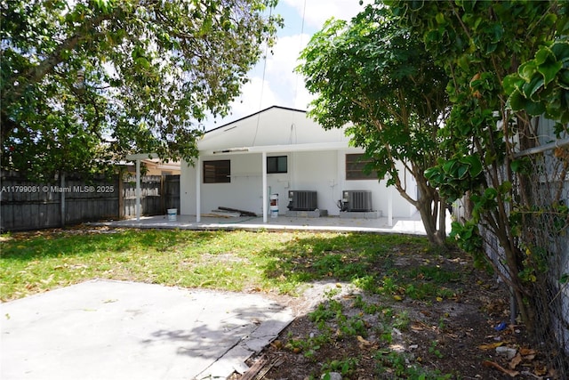 rear view of house with a patio, fence, central AC unit, and stucco siding