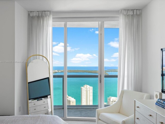 475 Brickell Ave Unit 5507, Miami, FL 33131 - carpeted bedroom with a water view, access to exterior, and a wall of windows