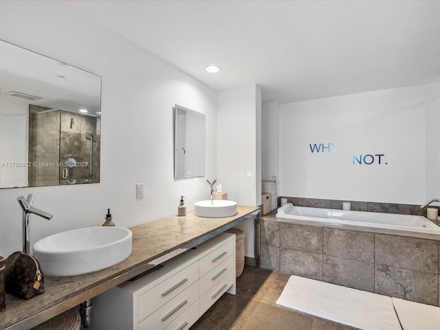 bathroom featuring a stall shower, a garden tub, double vanity, and recessed lighting