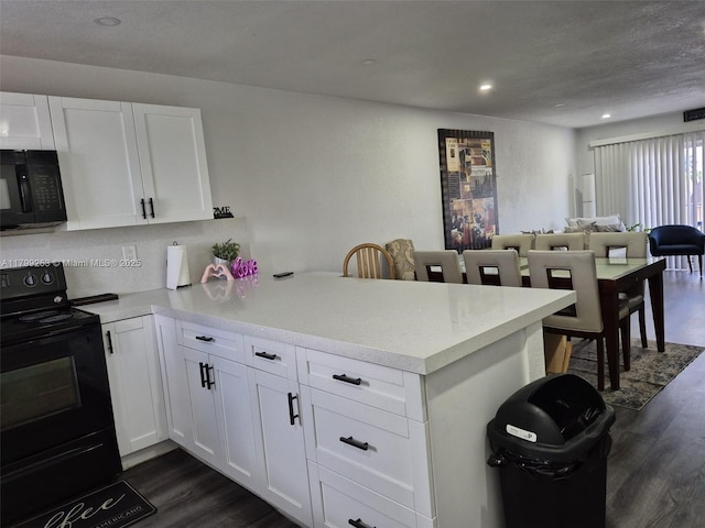 6850 W 16th Dr Unit 320, Hialeah, FL 33014 - kitchen with black appliances, a peninsula, dark wood-type flooring, light countertops, and recessed lighting