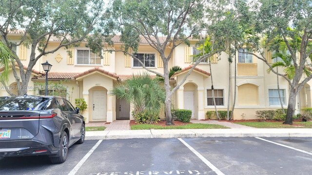 8353 SW 26th St Unit 104, Miramar, FL 33025 - view of property featuring uncovered parking, stucco siding, and a tiled roof