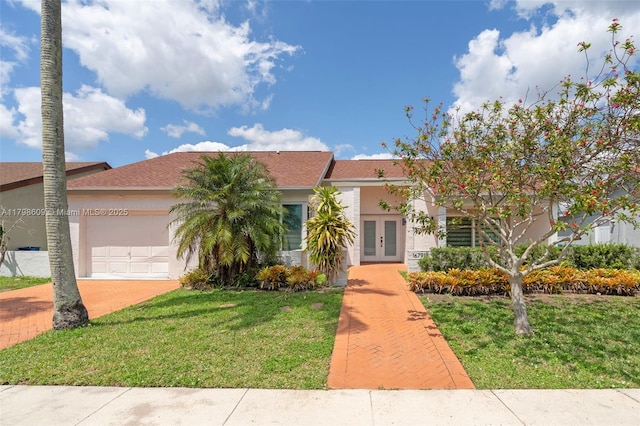 16791 Royal Poinciana Dr, Weston, FL 33326 - view of front of property featuring french doors, a garage, a front yard, stucco siding, and driveway