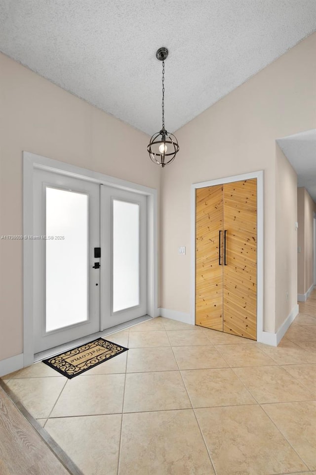 16791 Royal Poinciana Dr, Weston, FL 33326 - foyer featuring light tile patterned flooring, baseboards, a textured ceiling, french doors, and a chandelier