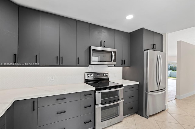 16791 Royal Poinciana Dr, Weston, FL 33326 - kitchen with stainless steel appliances, tasteful backsplash, light tile patterned floors, light stone counters, and recessed lighting