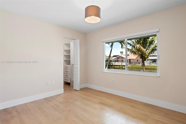 16791 Royal Poinciana Dr, Weston, FL 33326 - unfurnished bedroom featuring baseboards, wood finished floors, a walk in closet, and a closet