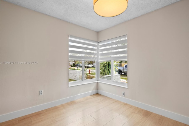 16791 Royal Poinciana Dr, Weston, FL 33326 - empty room with baseboards, a textured ceiling, and wood finished floors