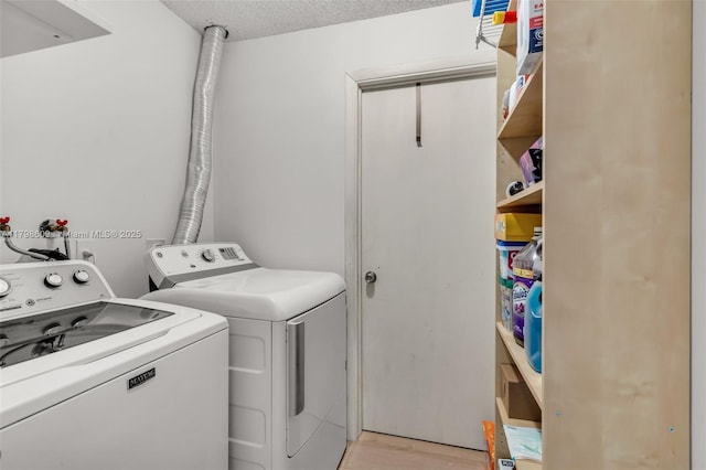 16791 Royal Poinciana Dr, Weston, FL 33326 - washroom with washing machine and clothes dryer, light wood-style flooring, and a textured ceiling