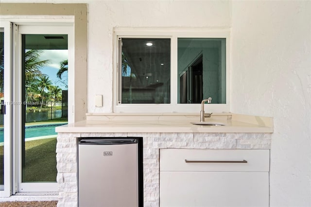 16791 Royal Poinciana Dr, Weston, FL 33326 - detailed view of a sink, freestanding refrigerator, stucco siding, and a pool