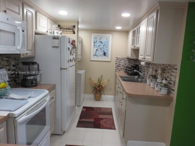 7040 SW 24th St Unit 104, Miami, FL 33155 - kitchen with white appliances, tasteful backsplash, a sink, washer / clothes dryer, and light countertops