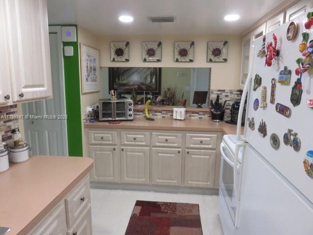 7040 SW 24th St Unit 104, Miami, FL 33155 - kitchen featuring white appliances, decorative backsplash, light countertops, white cabinets, and recessed lighting