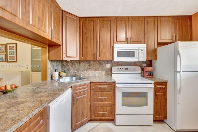 7080 Environ Blvd Unit 223, Lauderhill, FL 33319 - kitchen with white appliances, a sink, brown cabinetry, light countertops, and light tile patterned floors