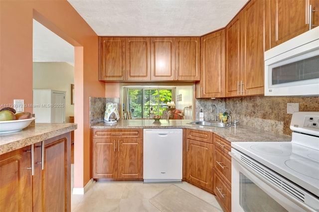 7080 Environ Blvd Unit 223, Lauderhill, FL 33319 - kitchen with white appliances, a sink, brown cabinets, light countertops, and backsplash